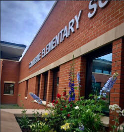 Front of Columbine Elementary School with the school sign and a flower bed