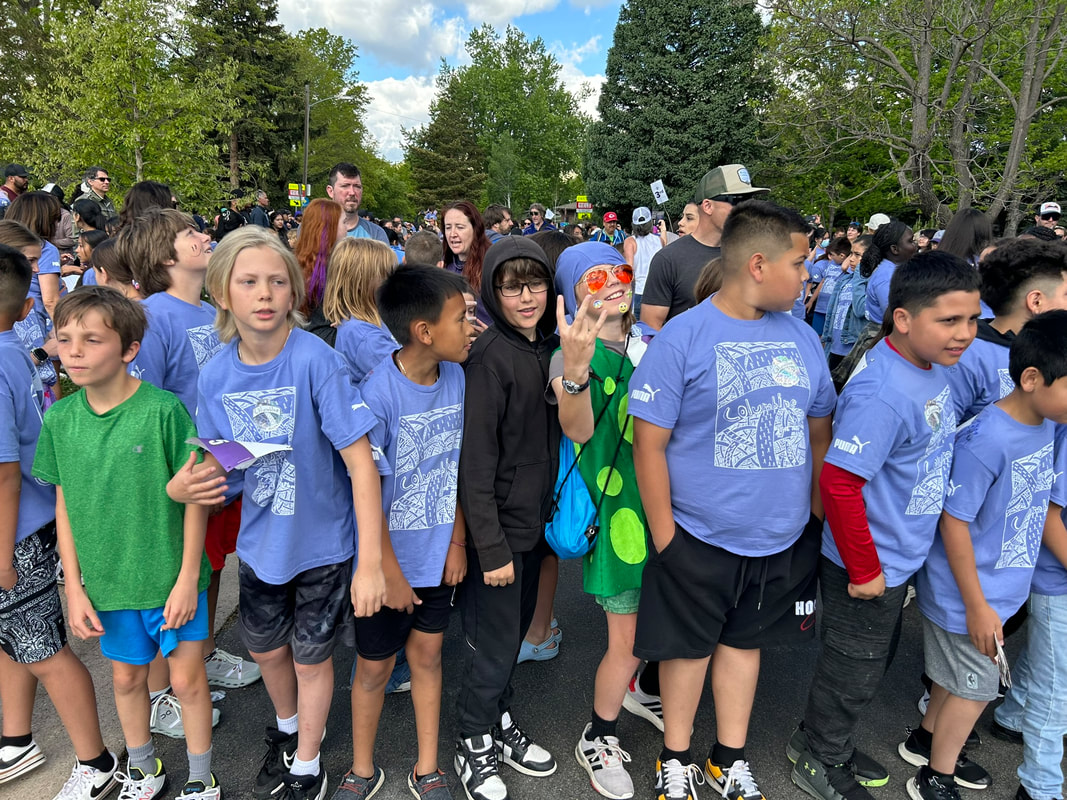 Columbine students in matching blue Mile Marathon T-shirts lined up at the start, with parents behind them