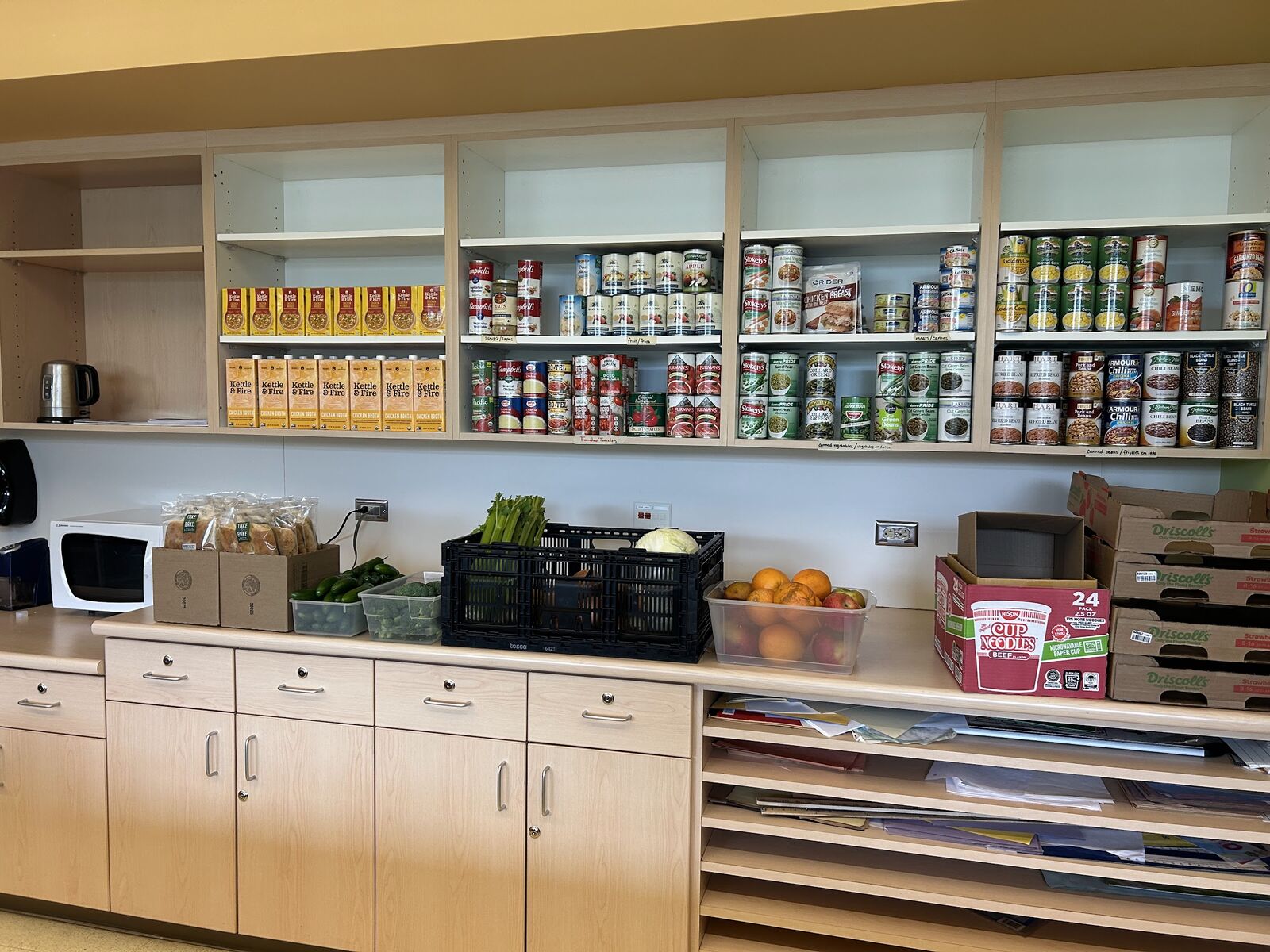 Estantes con comida enlatada, cereal y pasta en el Centro de Suministros para Superhéroes